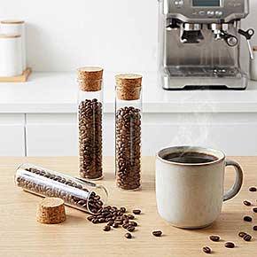 Reagenzglas aus klarem Glas mit Korkverschluss, gefüllt mit Kaffeebohnen – stilvolle Glasröhre zur Kaffeeaufbewahrung